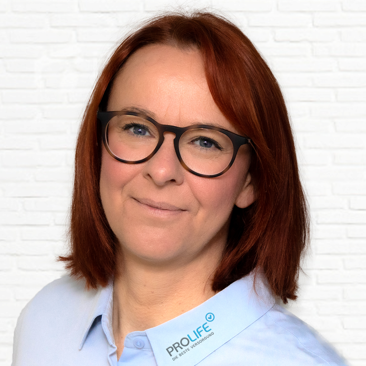 Porträt einer Frau mit Brille und rotem Haar