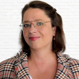 Porträt einer Frau mit kariertem Blazer und Brille