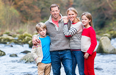 Familie am Flussufer in herbstlicher Natur