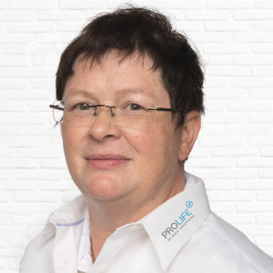 Portrait einer Person mit Brille vor Ziegelwand
