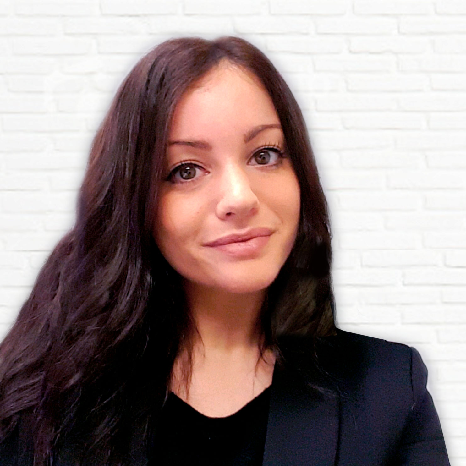 Frau mit dunklen Haaren und Ziegelwand im Hintergrund