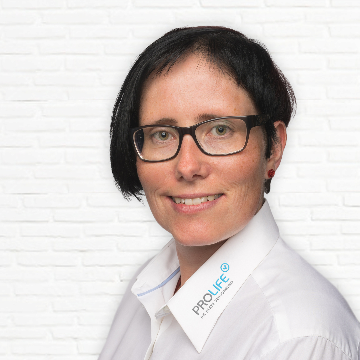 Porträt einer Frau mit Kurzhaarfrisur und Brille